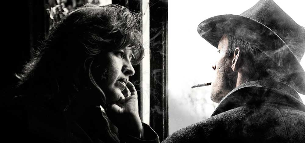 Eine nachdenklich wirkende Frau und ein Zigarette rauchender Mann unterhalten sich vor einem geöffneten Fenster