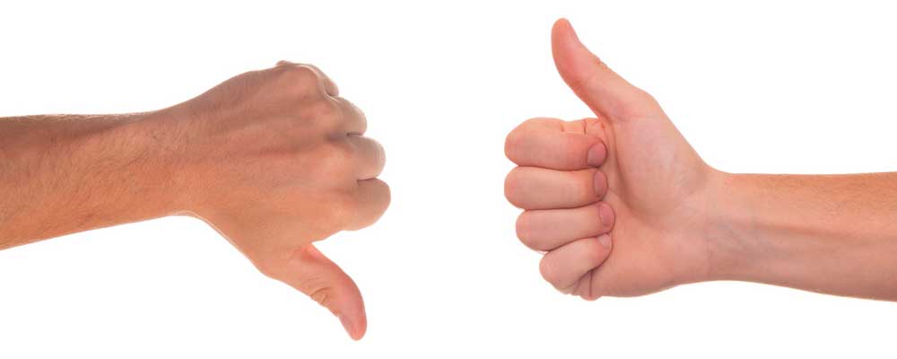 Ein farbiges Foto, dass zwei Hände vor einem weißen Hintergrund zeigt. Der Daumen der linken Hand zeigt nach unten, der Daumen der rechten Hand nach oben als Symbol für die Schwierigkeit von fundierten Beurteilungen.