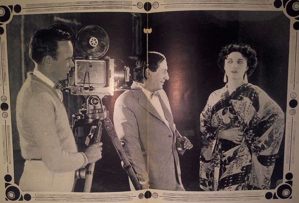 Schwarzweiß Postkarte, die Ernst Lubitsch, den Meister der Romantischen Komödie, bei Dreharbeiten zeigt.