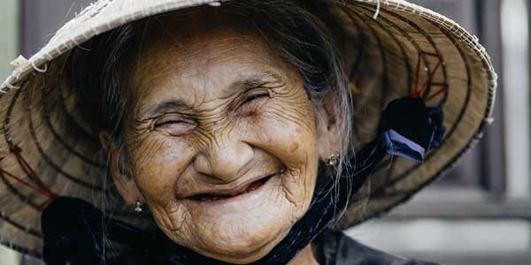 Farbiges Foto für die-besten-spielfilme: das verschmitzte Lächeln einer älteren Frau mit vielen Lachfalten im Gesicht.