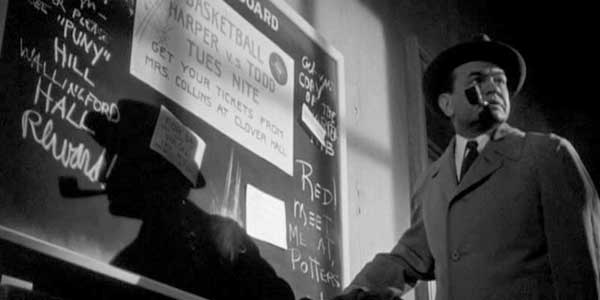 Schwarzweißes Szenenfoto für die-besten-spielfilme: Schauspieler Edward G. Robinson mit einer Pfeife im Mundwinkel am Eingang einer Nachtbar.