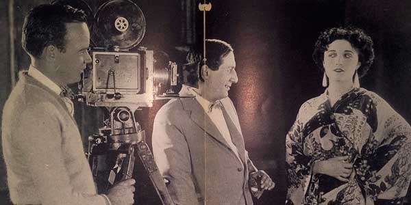 Schwarzweißes Setfoto für die-besten-spielfilme: Dreharbeiten einer romantischen Komödie mit Regisseur Ernst Lubitsch und Schauspielerin Pola Negri.