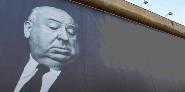 Auf einer riesigen Kinoleinwand ist Alfred Hitchcock - der Meister des Thrillers - abgebildet.